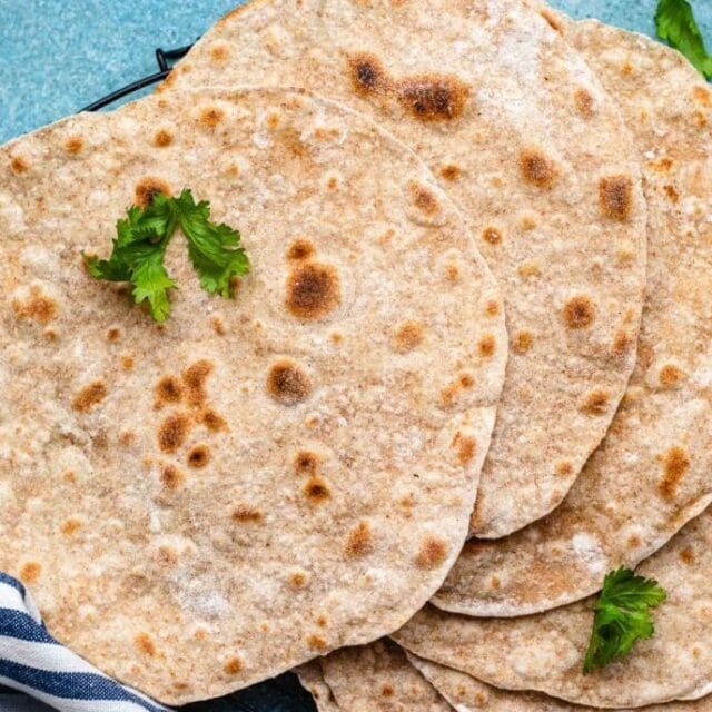 Indian flatbread laid out on a blue and white towel.