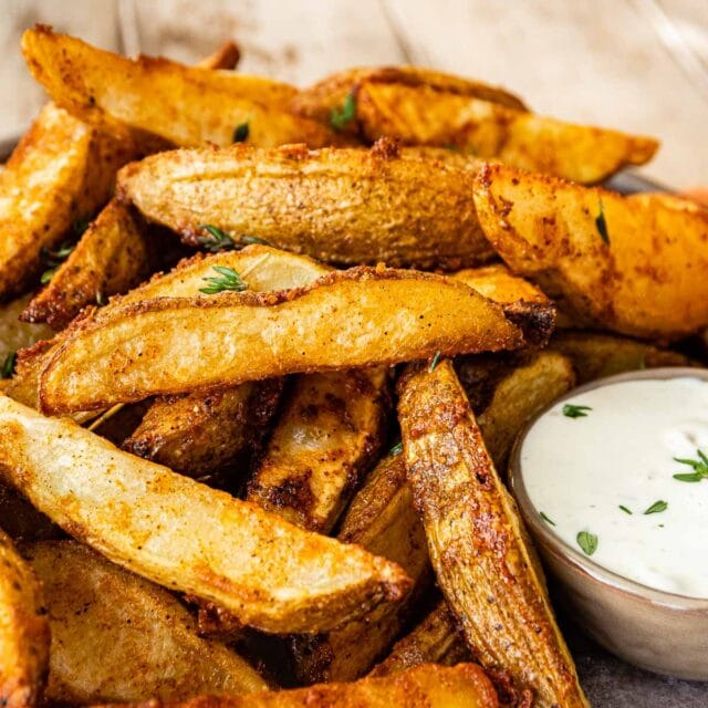 closeup of cooked potato wedges with dipping ranch