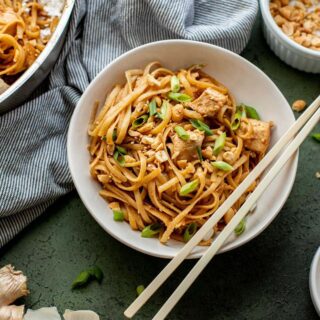 Sesame Peanut Chicken Noodles in a bowl with chopsticks