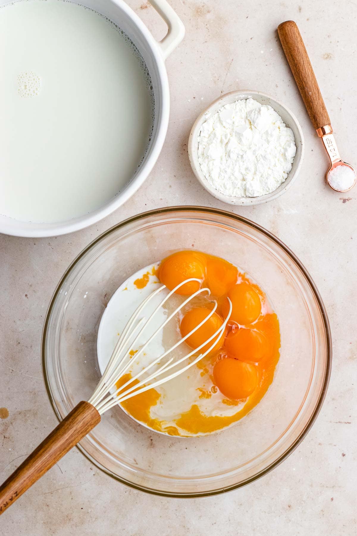 Vanilla Pudding egg yolks and sugar in bowl with whisk before mixing