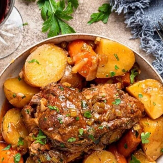 a bowl of chops with carrots and potatoes