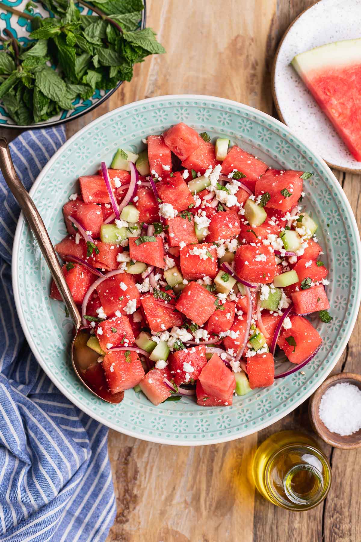 Watermelon Feta Salad in a bowl with spoon and decorative pieces surrounding