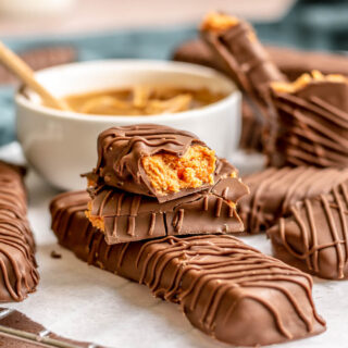 Candy Bars finished in a stack on board with dish of peanut butter. Top bar broke in half to show inside, 4x3