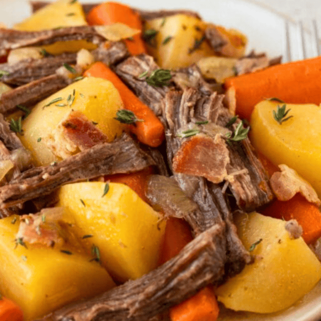Close up of plate of roast and vegetables with fork