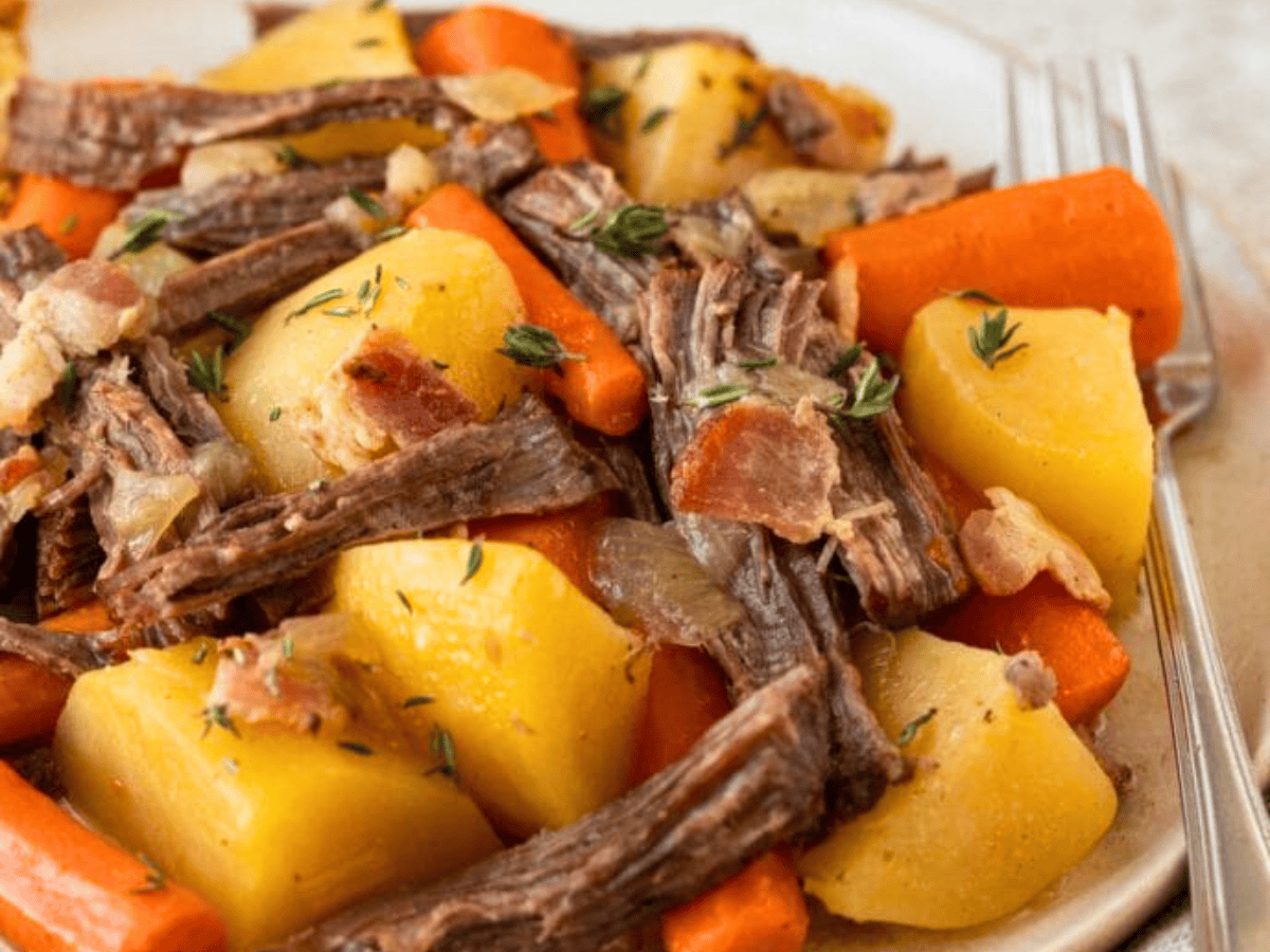 Close up of plate of roast and vegetables with fork