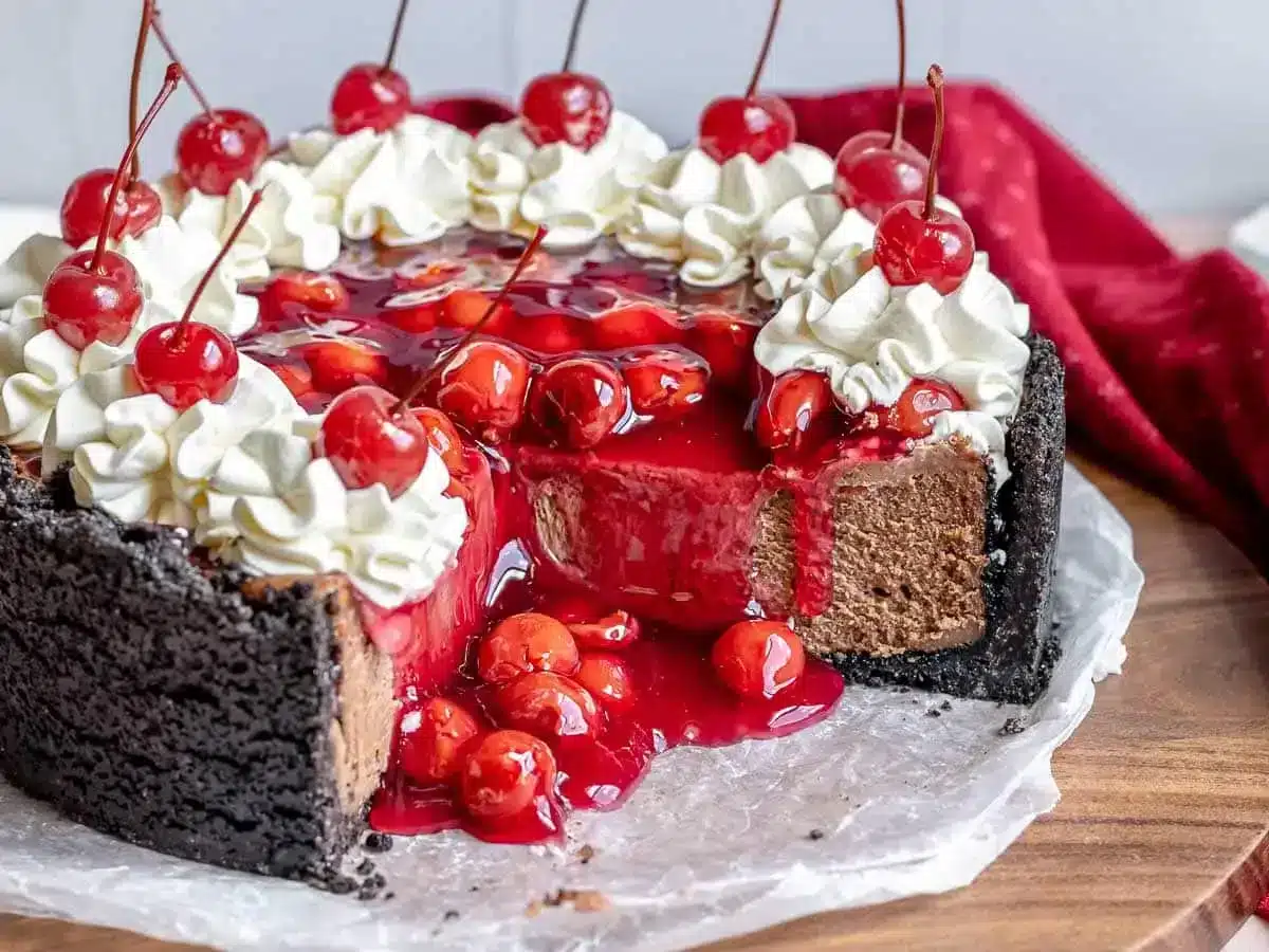 cheesecake with pieces missing and cherry topping falling down 