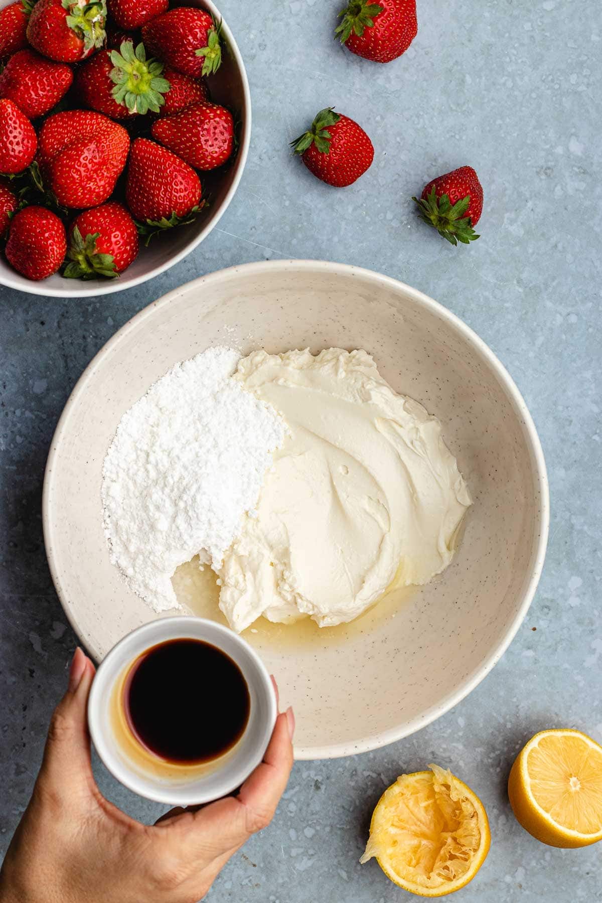 bowl of cream cheese mixture next to bowl of strawberries