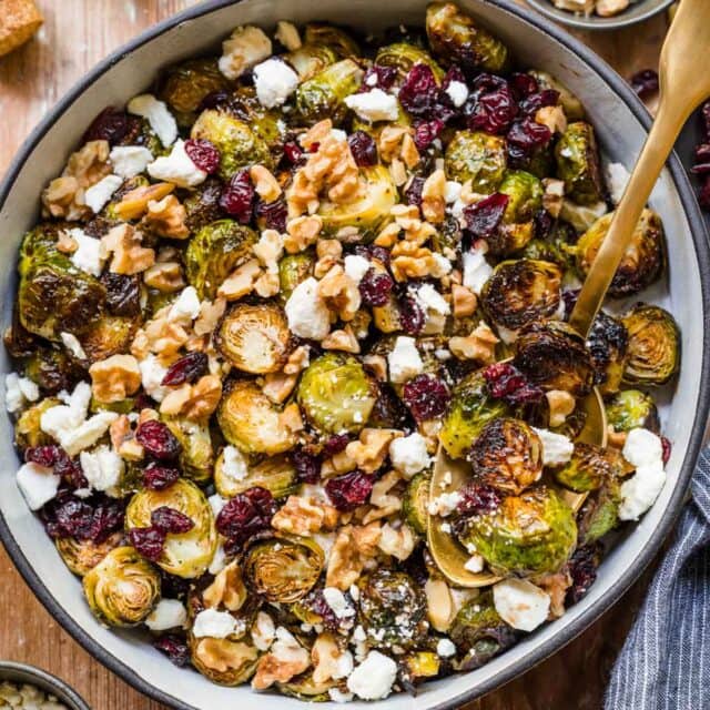 Cranberry Goat Cheese Brussels Sprouts in a serving bowl with spoon