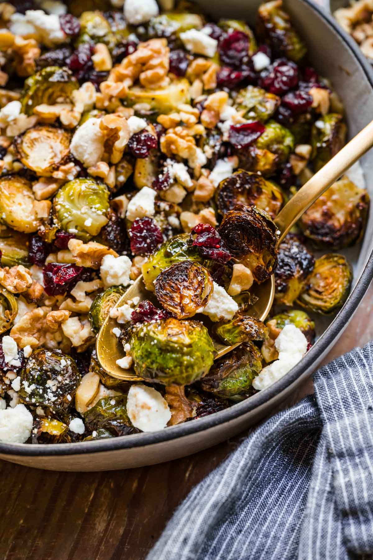 Cranberry Goat Cheese Brussels Sprouts in a serving bowl with spoon
