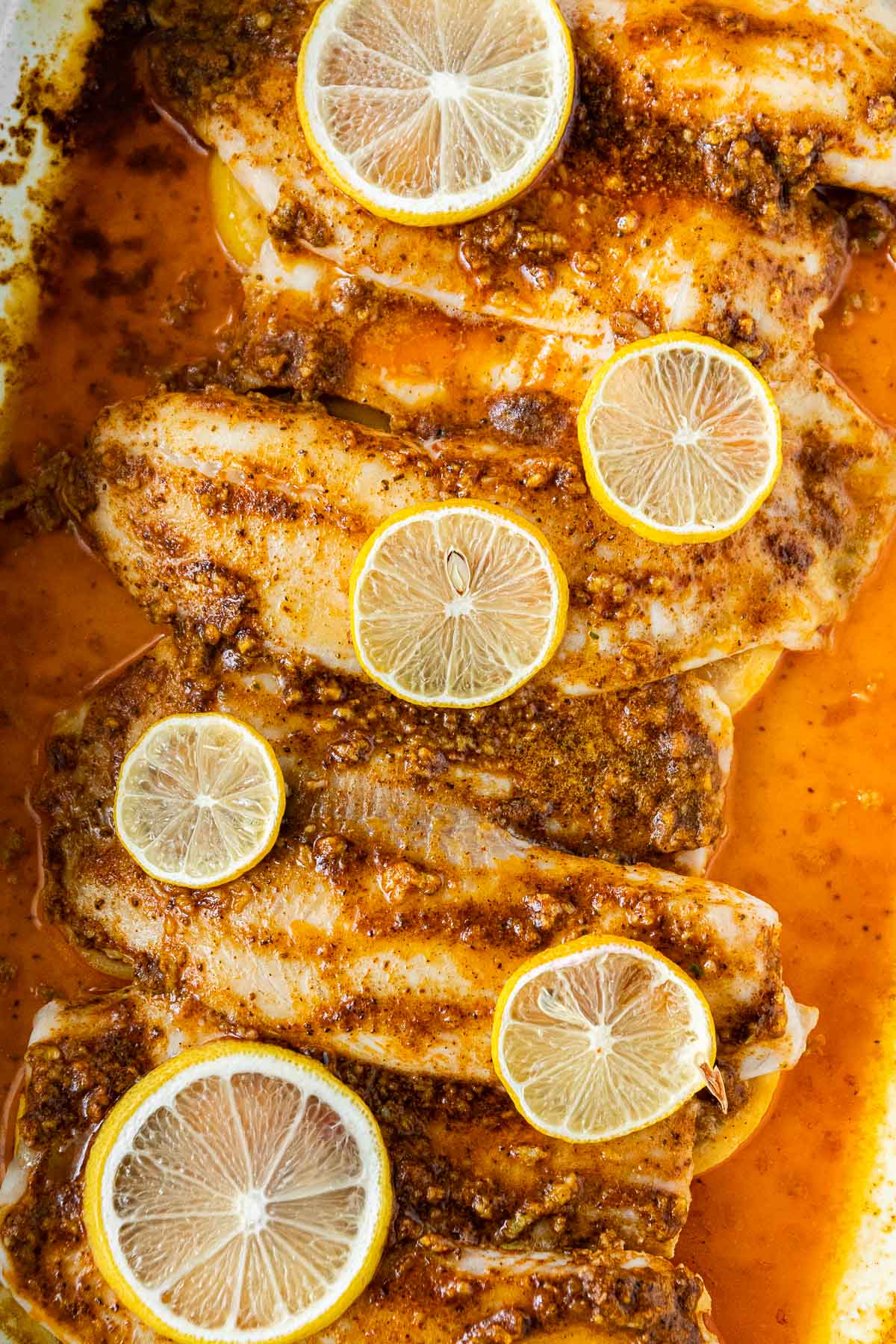 cooked fish with lemons in dish 