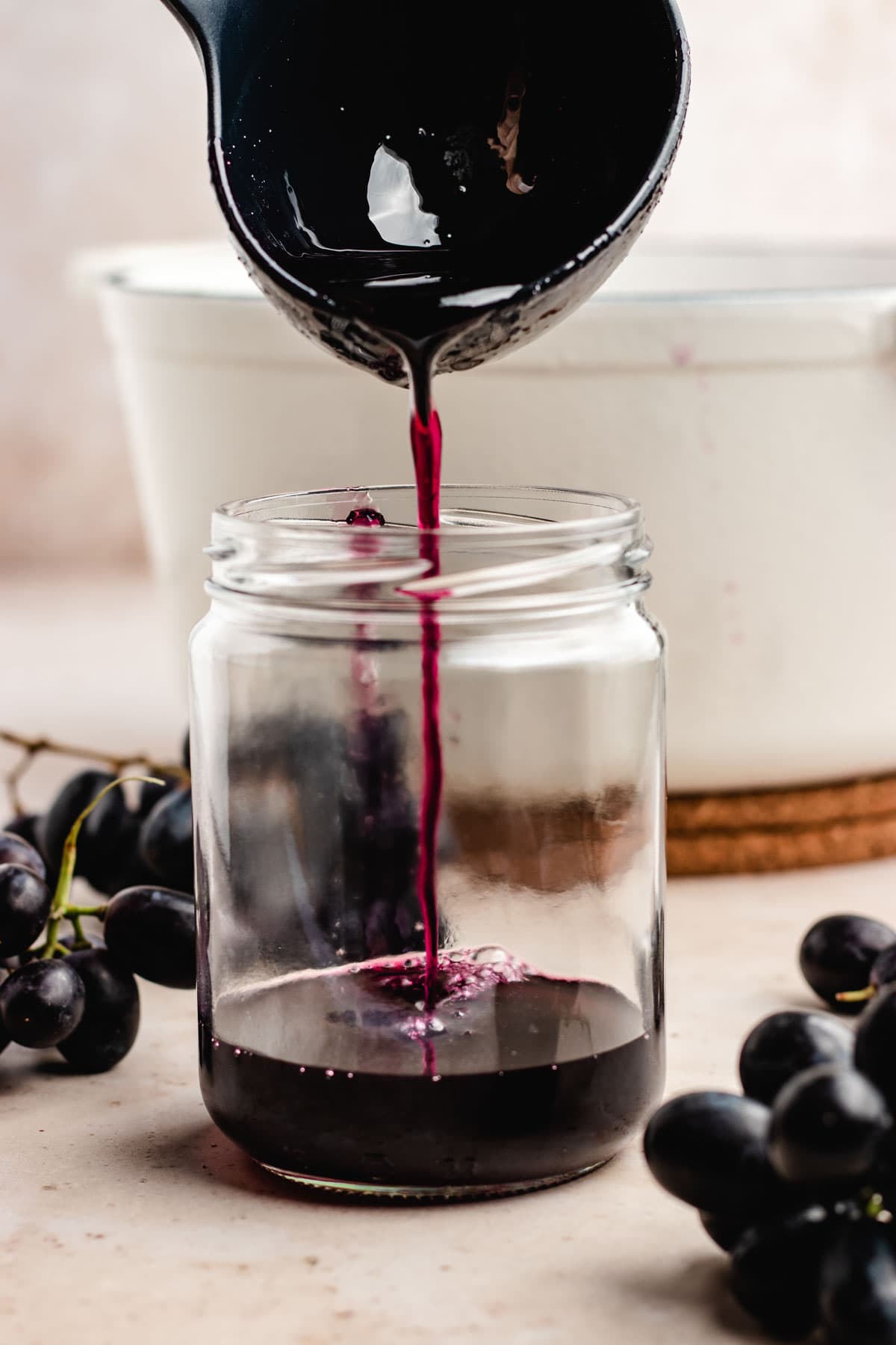 Homemade Grape Jelly being poured into glass jar