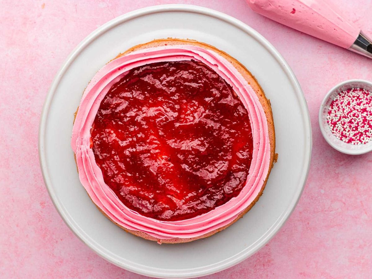 Top view of cake with a ring of frosting and jam spread