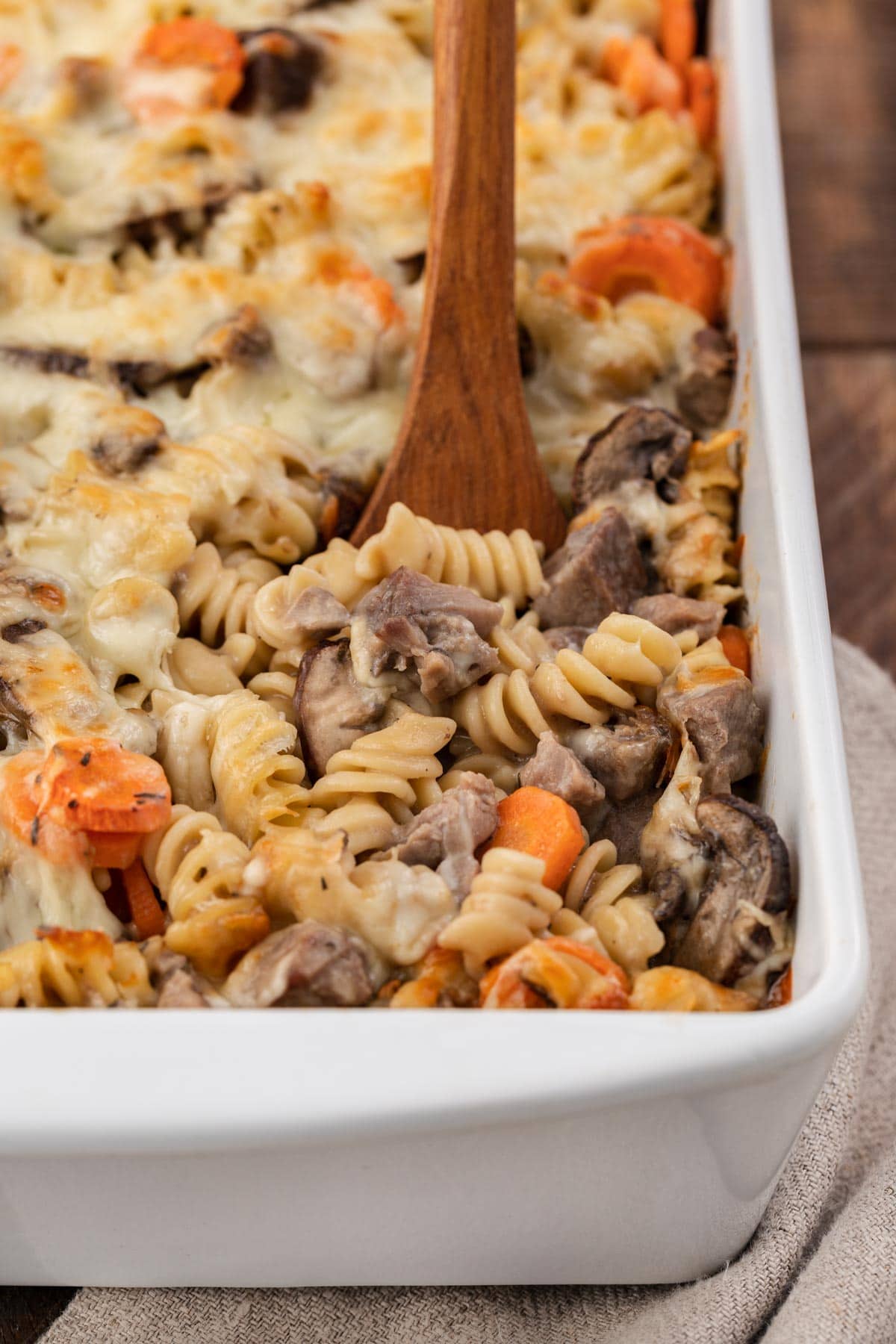 closeup of Roast Beef Noodle Casserole in the baking sheet with wooden serving spoon
