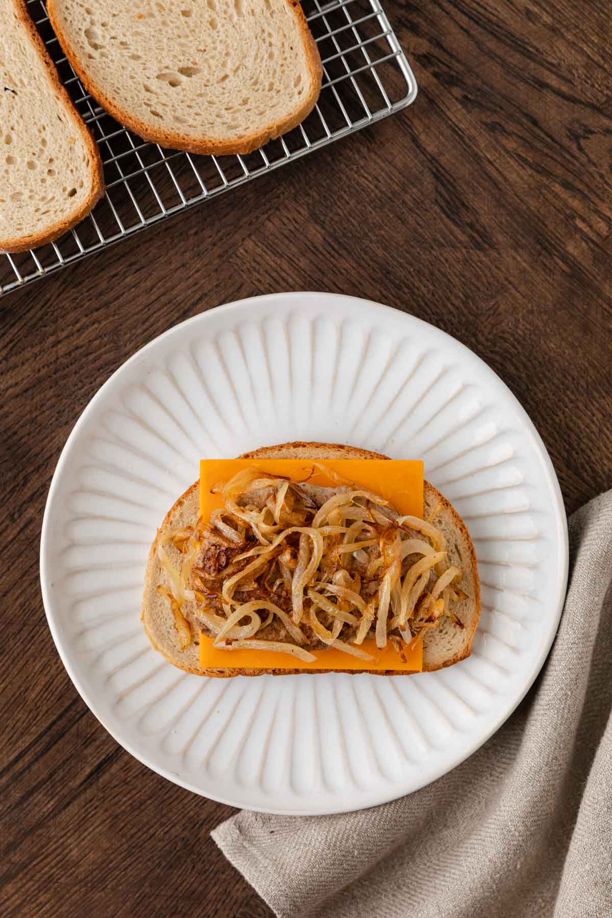 slice of bread with cheese and turkey patty and fried onions