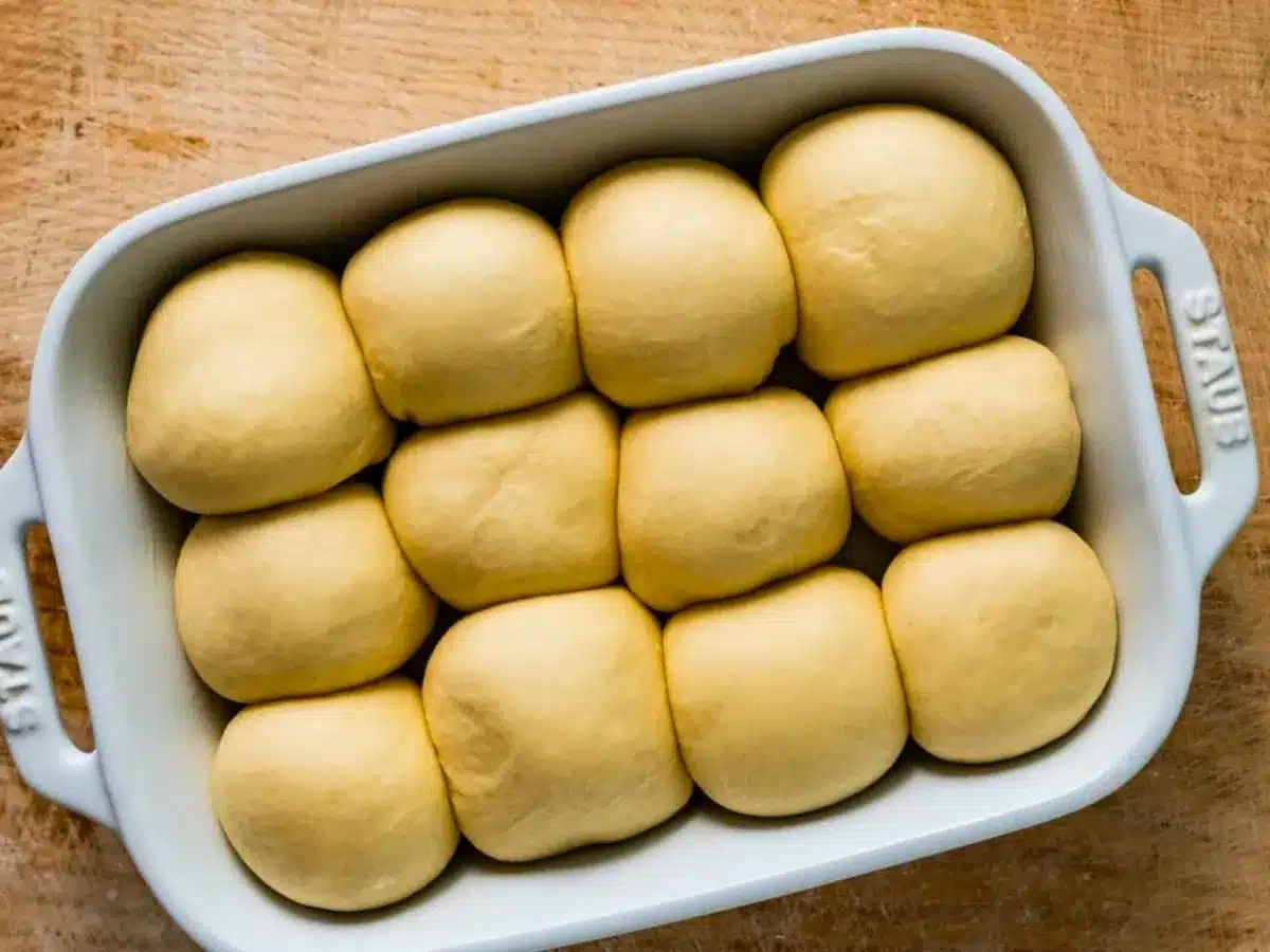 Raw dinner rolls in pan