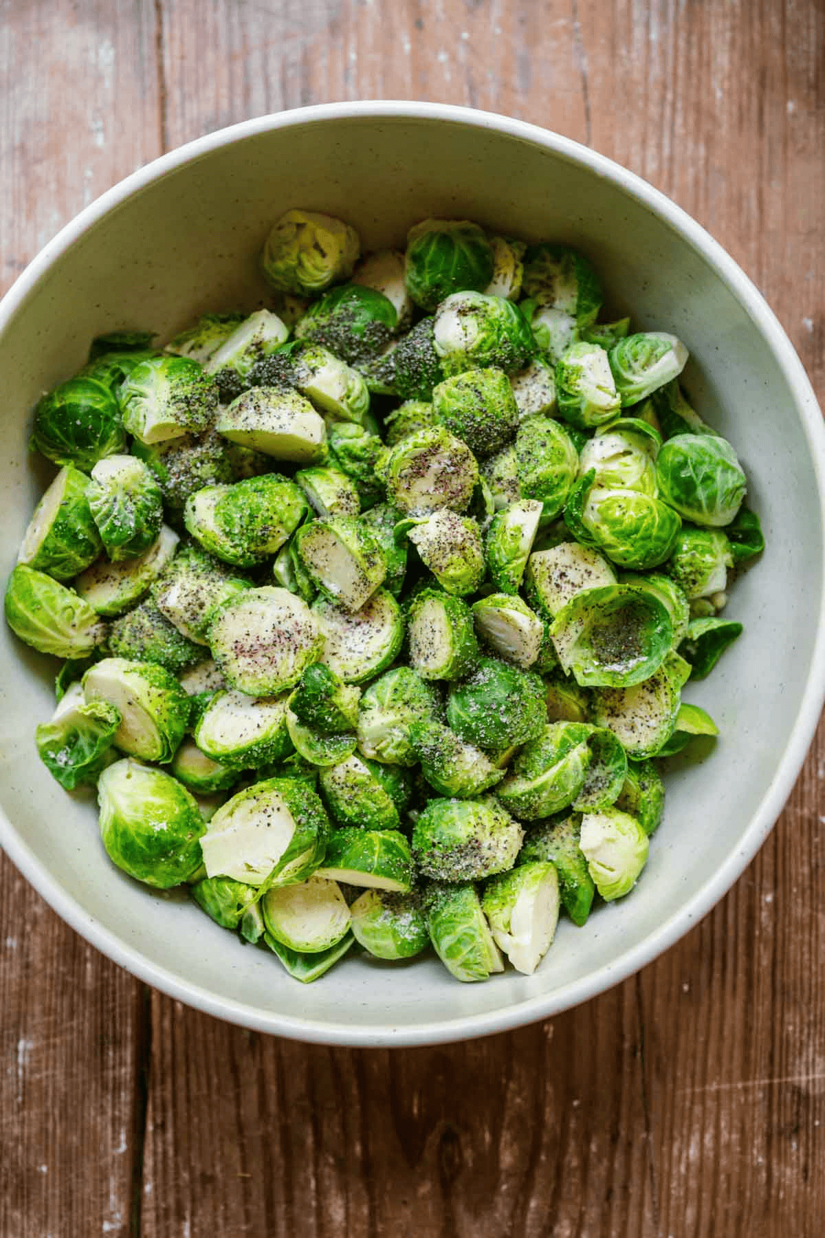 sliced Brussels sprouts in a bowl with seasoning