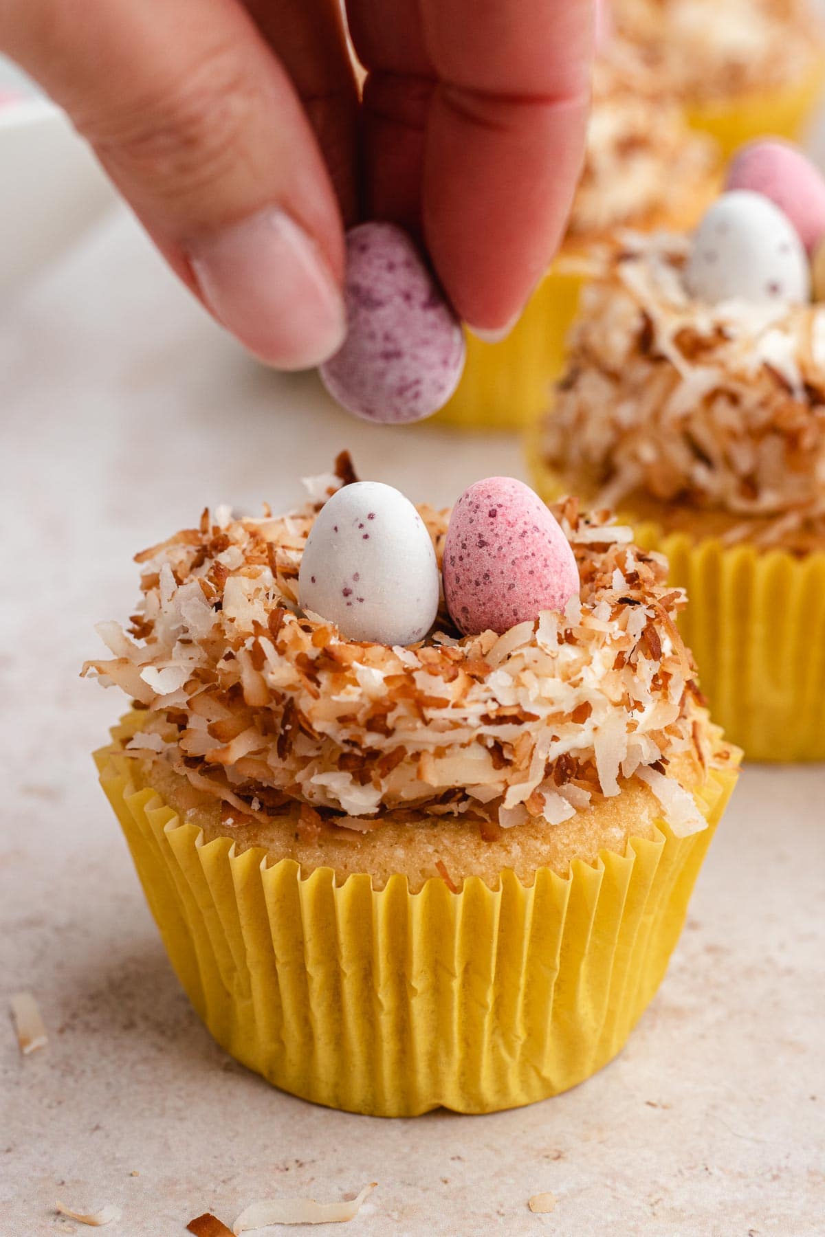 Easter Egg Nest Cupcakes, candy Egg being placed on top