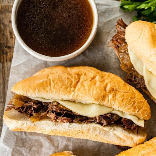 3 French dip sandwiches with a small side of au jus