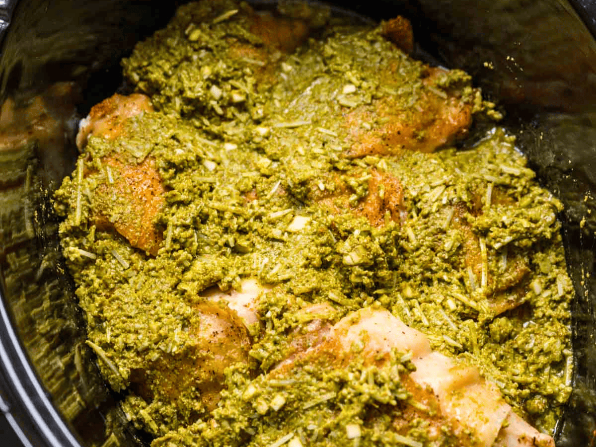 chicken in pot covered in green seasoning