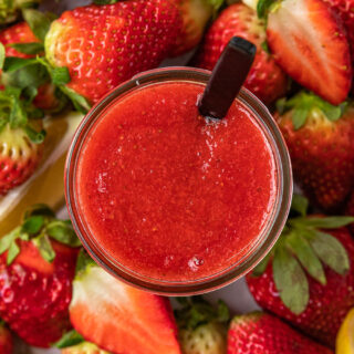 top down view of puree in jar with spoon with berries all around jar, 4x3