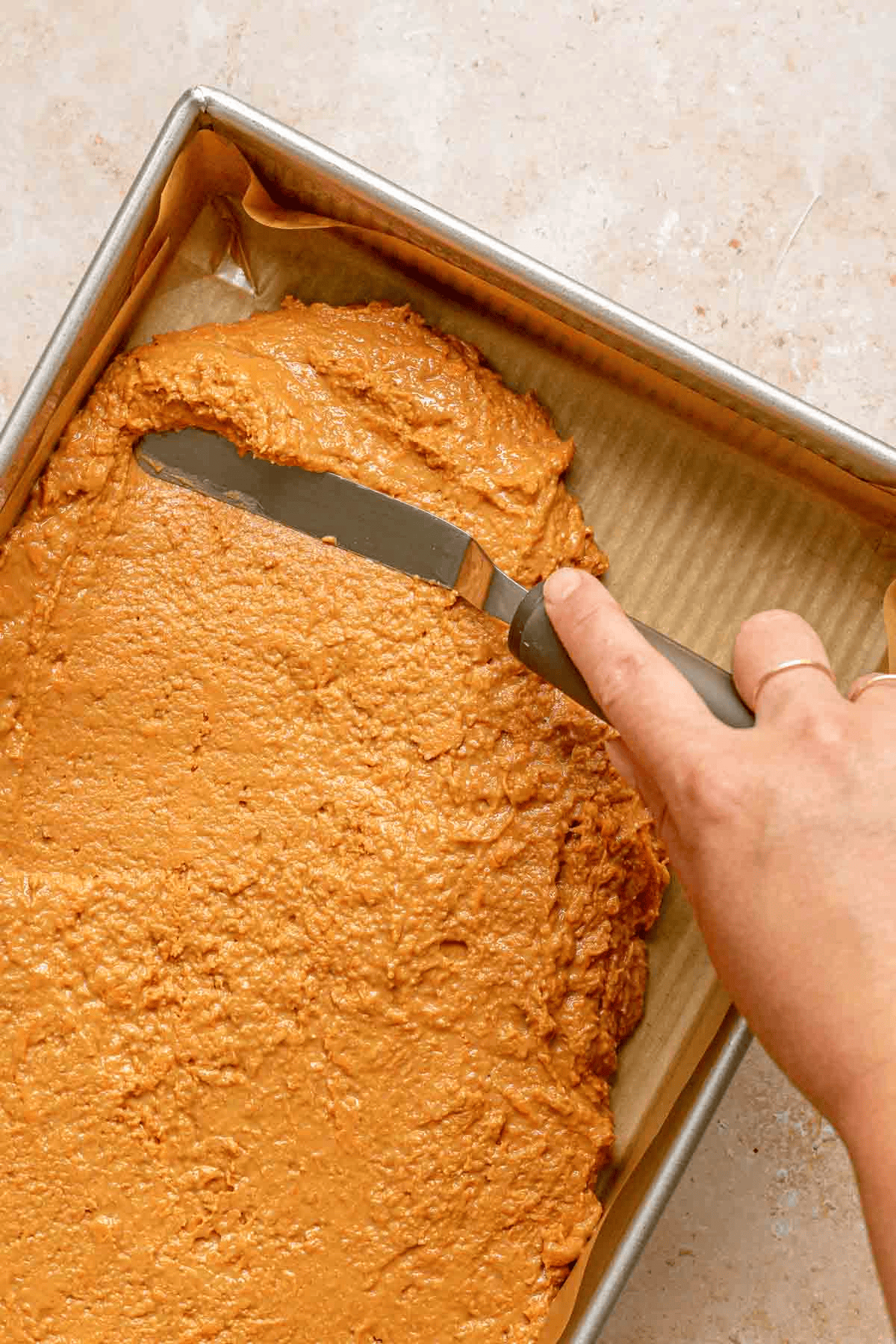 Spreading peanut butter mixture in a pan