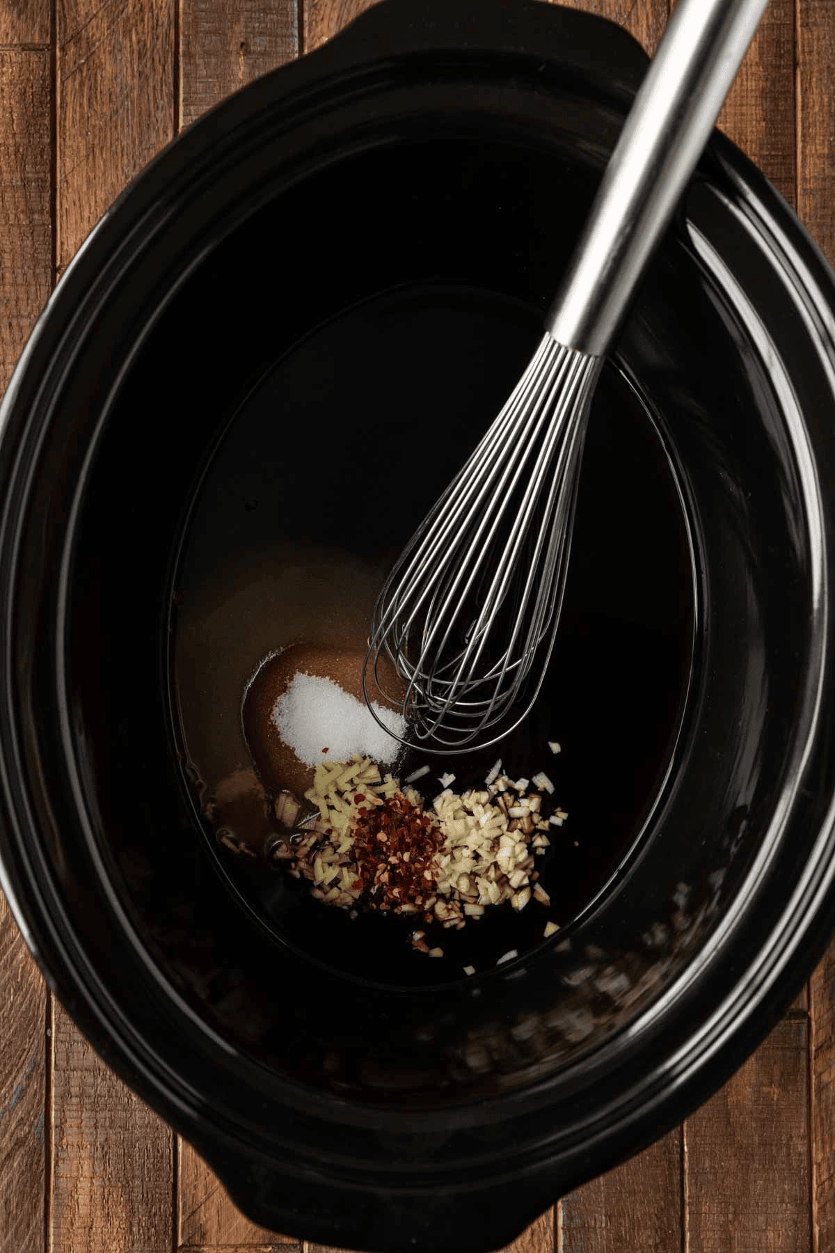Whisk mixing sauce in slow cooker