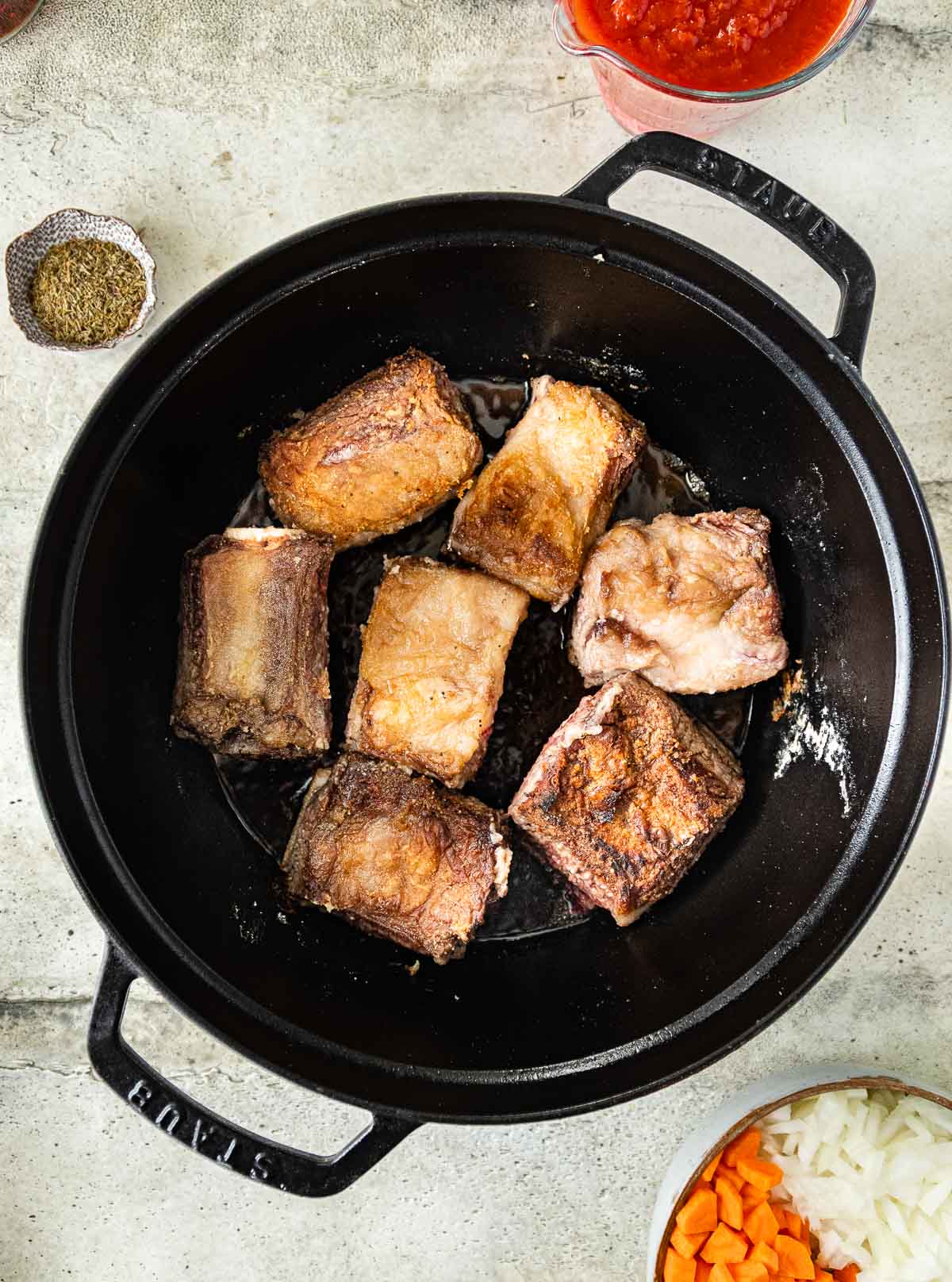portioned raw short ribs coated in cornflour browned in a skillet