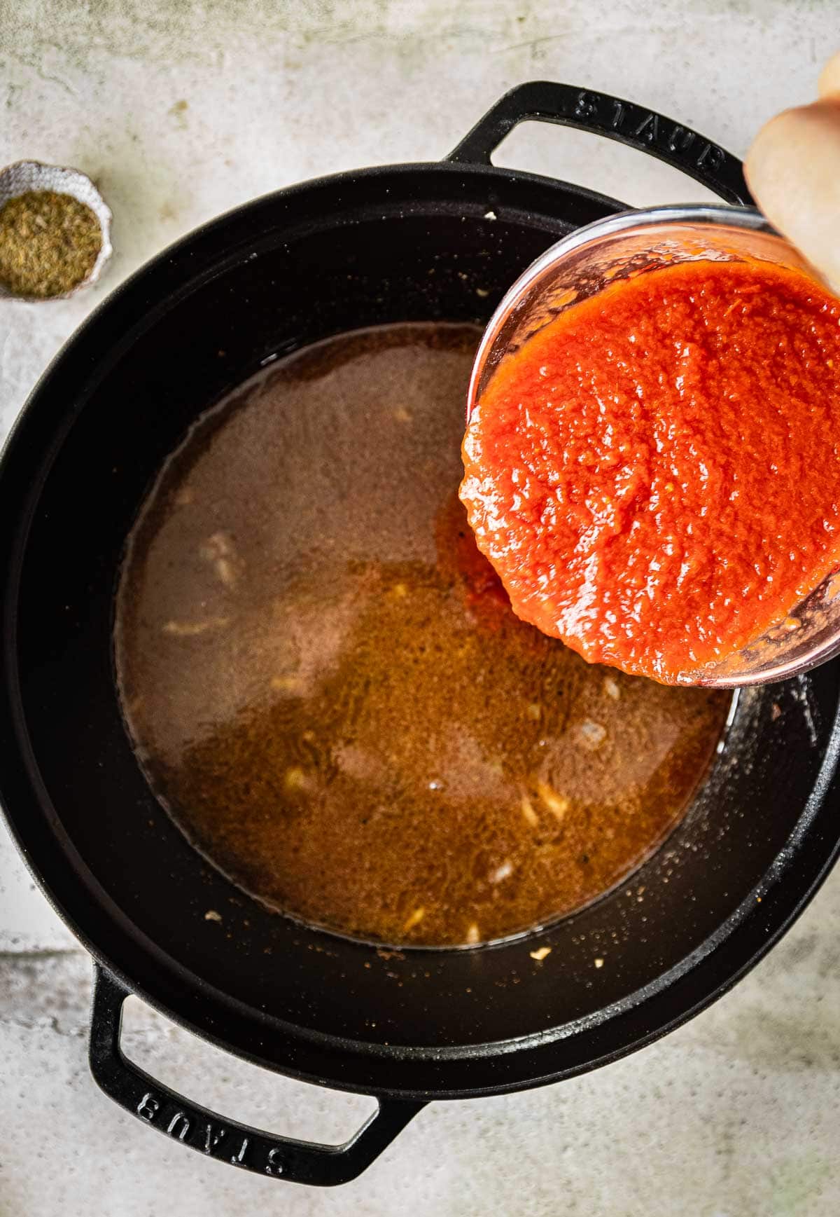 adding crushed tomatoes to the braising liquid