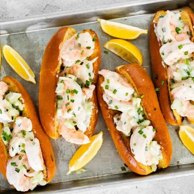 4 rolls filled with seafood on a sheet tray