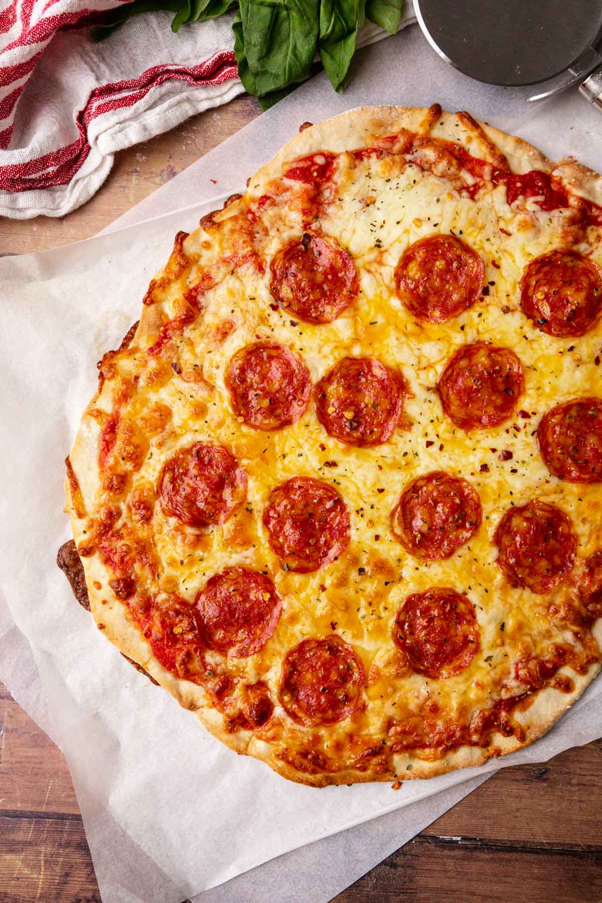 Thin Crust Pepperoni Pizza cooked pizza on parchment paper