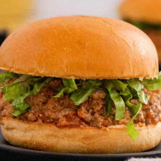 Closeup of meat and bun with lettuce on a plate ready to eat