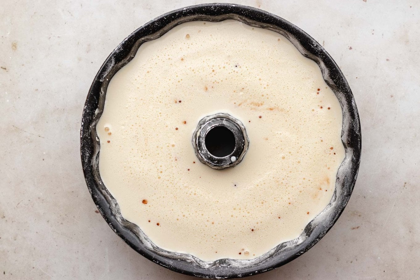 Chocoflan cake batter and flan layer assembled in Bundt pan before baking. horizontal photo