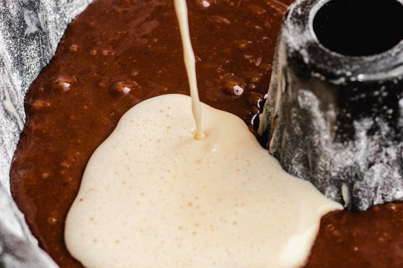 Chocoflan pouring flan into chocolate batter in bundt pan, horizontal crop