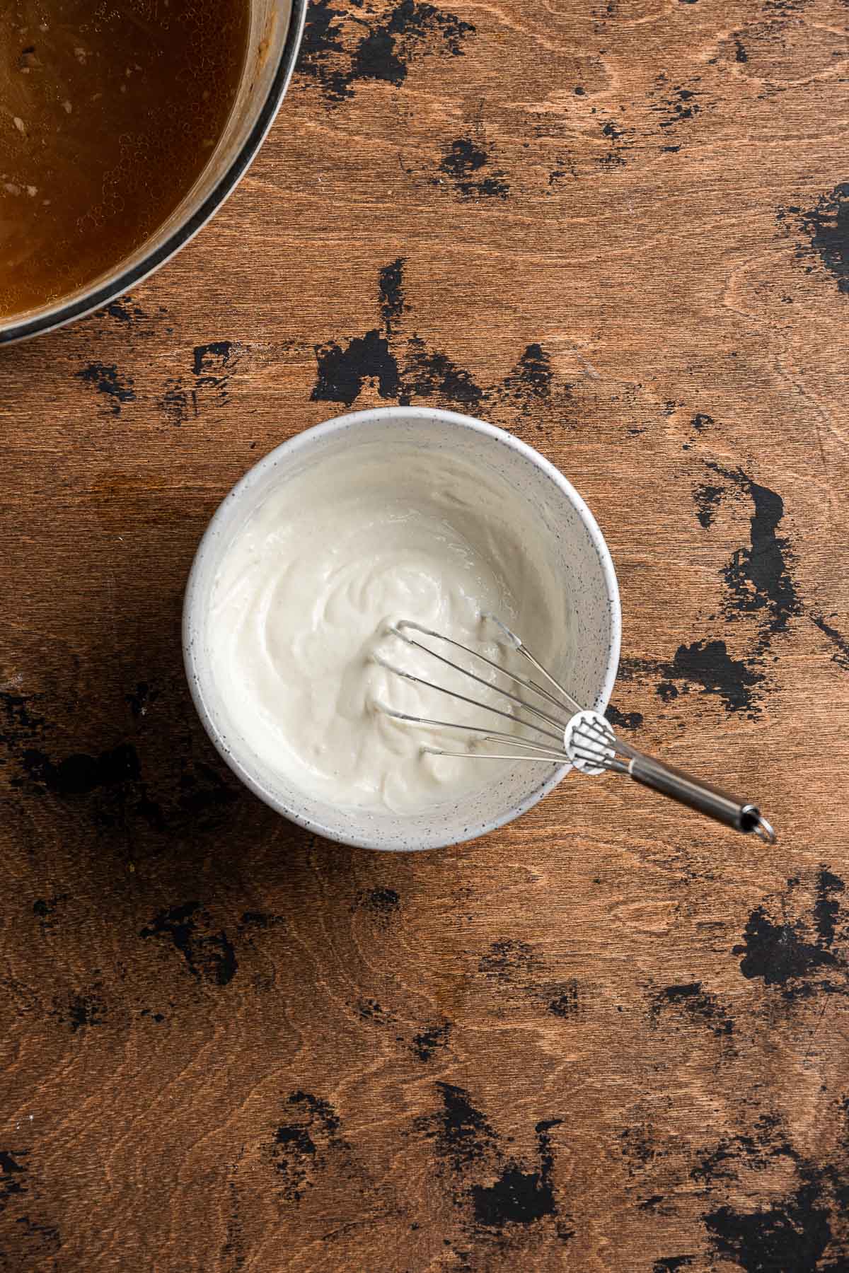 Creamy Garlic Mushroom Sauce sour cream and flour mixture whisked in bowl.