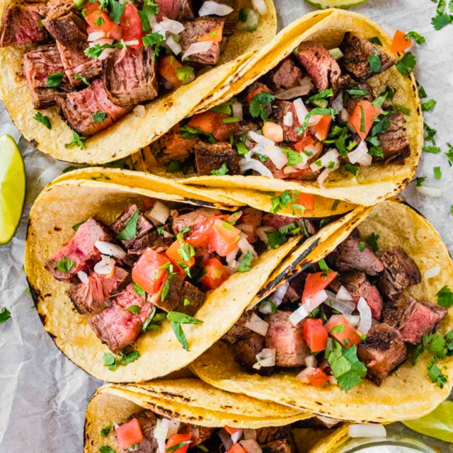 Steak tacos lined up next to each other