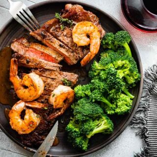 cooked steak and shrimp plated with broccoli and sauce