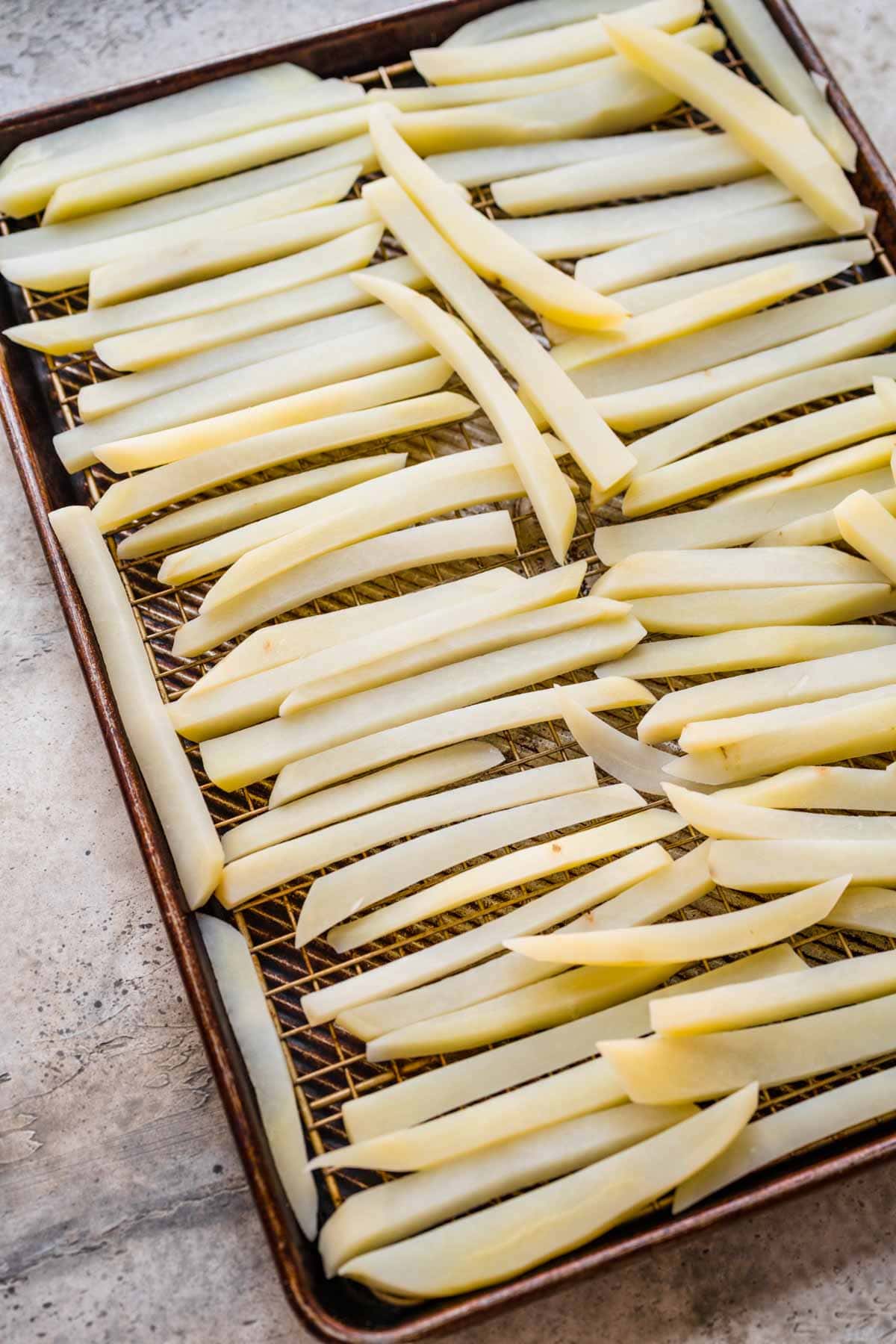 boiled raw french fries on drying rack