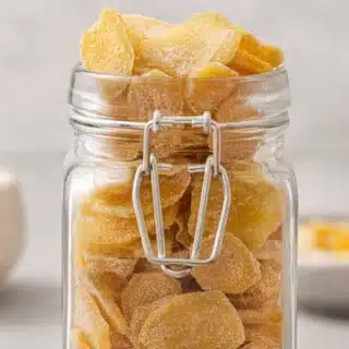 Glass jar filled with sugar coated ginger slices.