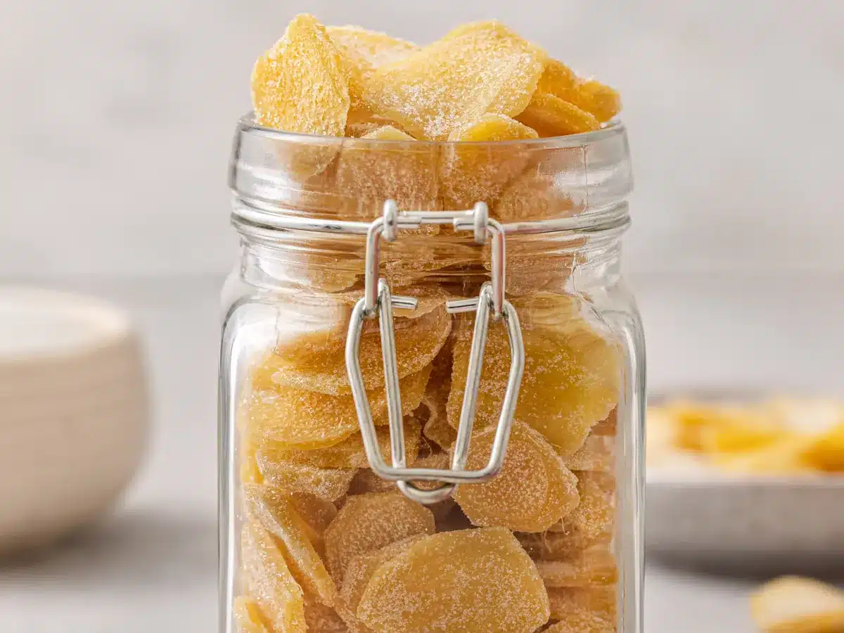 Glass jar filled with sugar coated ginger slices.