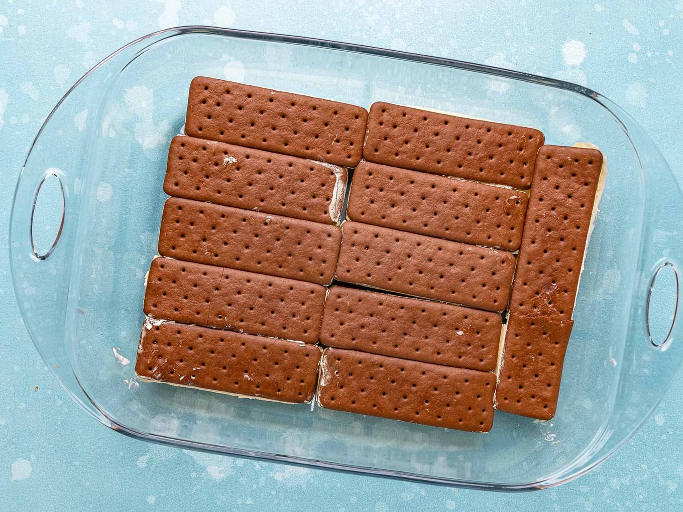 Ice Cream Sandwich Cake layer of ice cream sandwiches in bottom of 9x13 glass casserole dish.