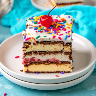 Ice Cream Sandwich Cake slice on plate topped with maraschino cherry. 4x3