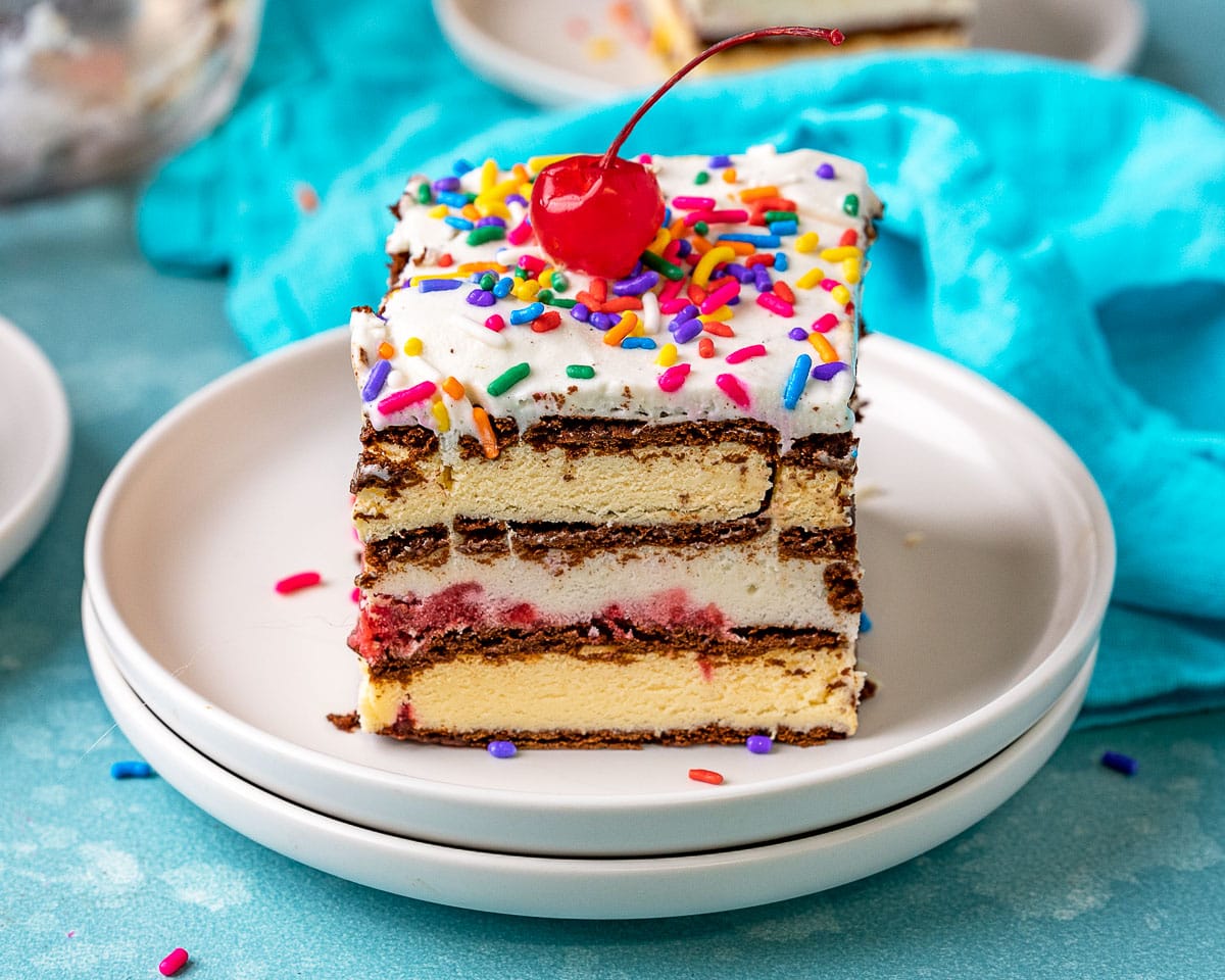 Ice Cream Sandwich Cake slice on plate topped with maraschino cherry. 4x3