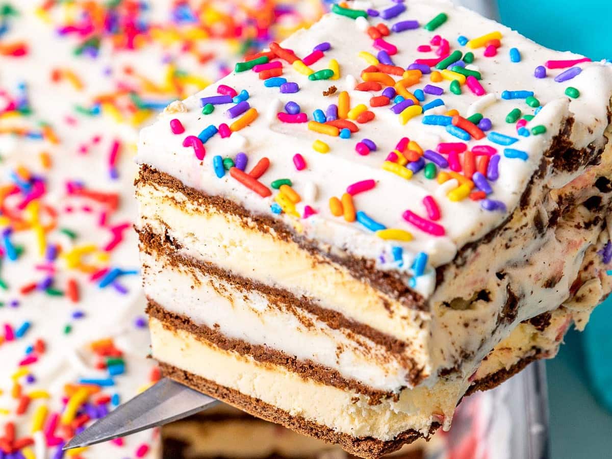 Ice Cream Sandwich Cake finished slice on server with remaining cake in casserole dish in background.