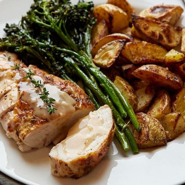 Chicken on a plate with greens and potatoes