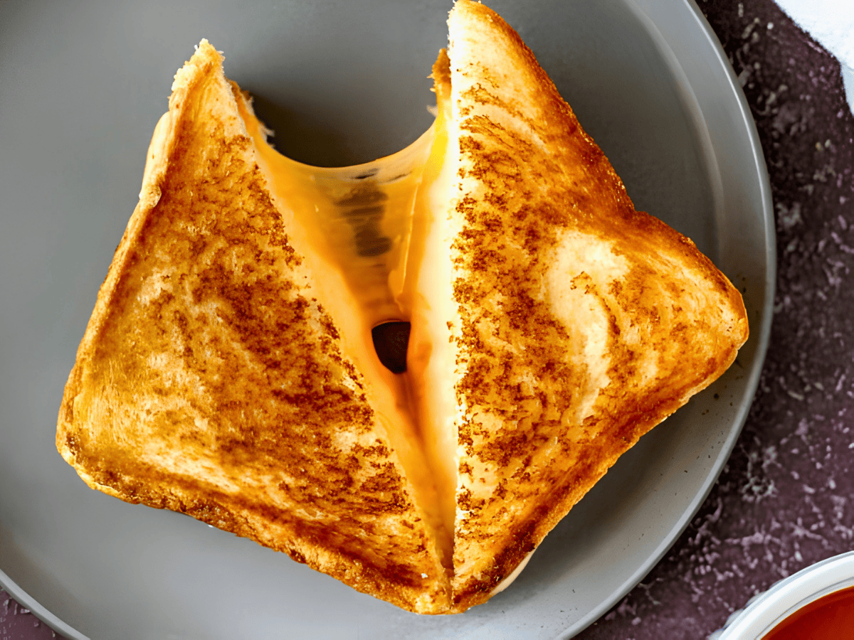 bread cut in half with a cheese pull on a plate