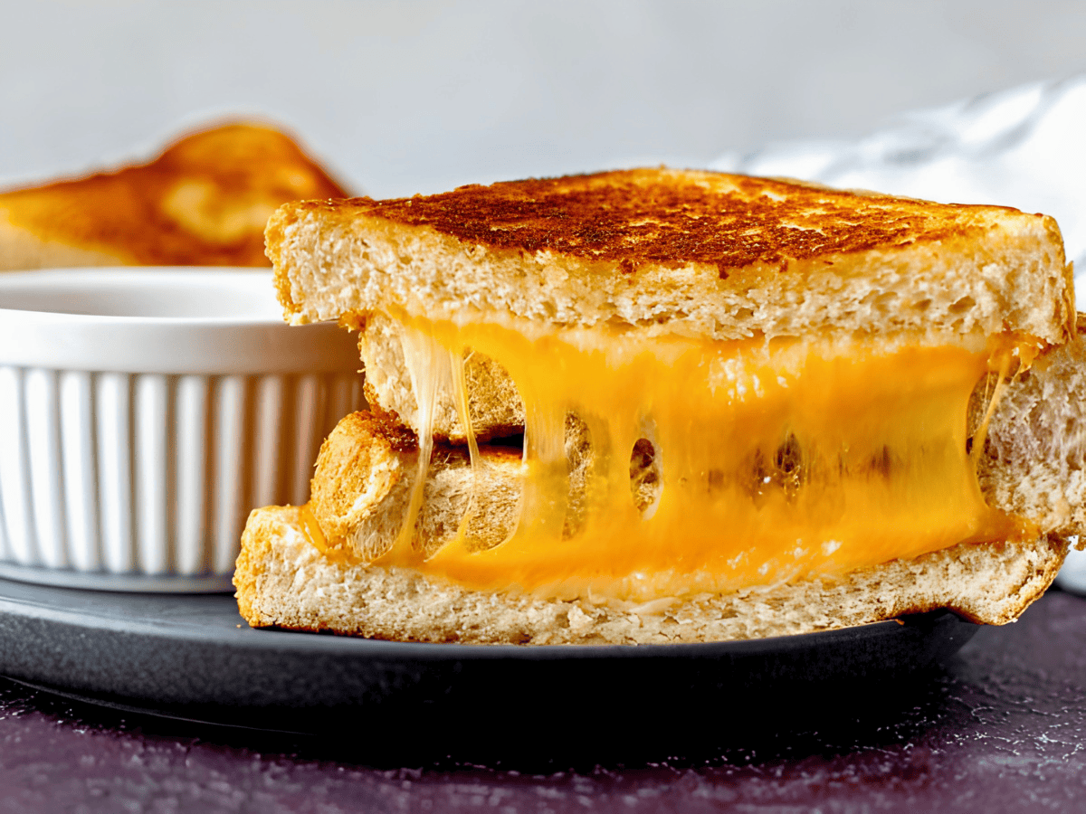 melted cheese in between slices of bread on a plate