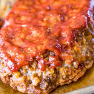 Glazed meatloaf cooked on a baking sheet on parchment paper.