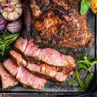 Cooked large steak sliced on a serving platter.