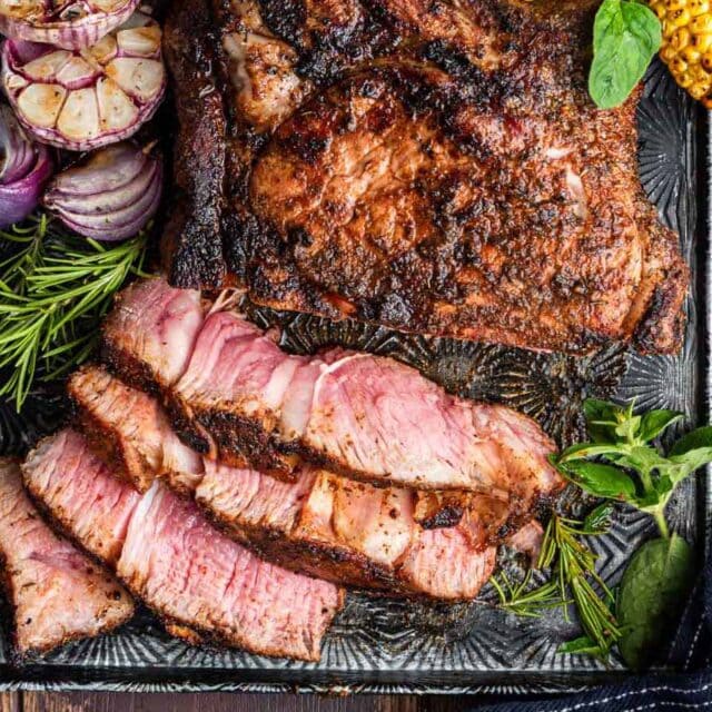Cooked large steak sliced on a serving platter.
