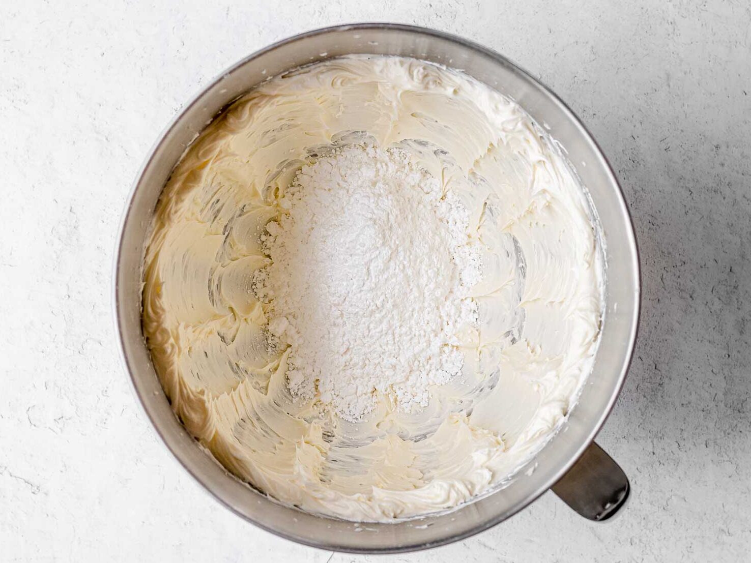 Unicorn Cupcakes creamed butter in mixing bowl and powdered sugar on top before mixing.